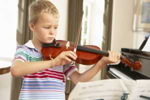 boy practicing violin at home